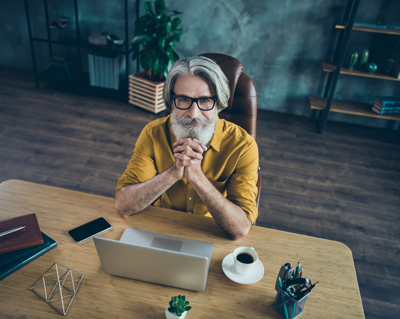 Man in a yellow shirt with his elbows resting on a table