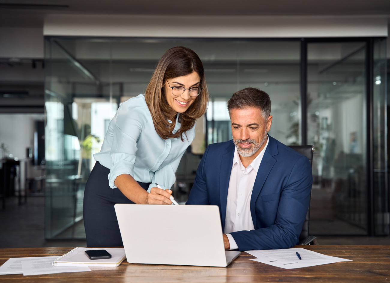 Two office workers looking at a laptop